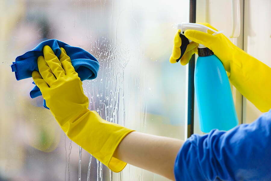 closeup of someone cleaning their inside window with a microfibre cloth